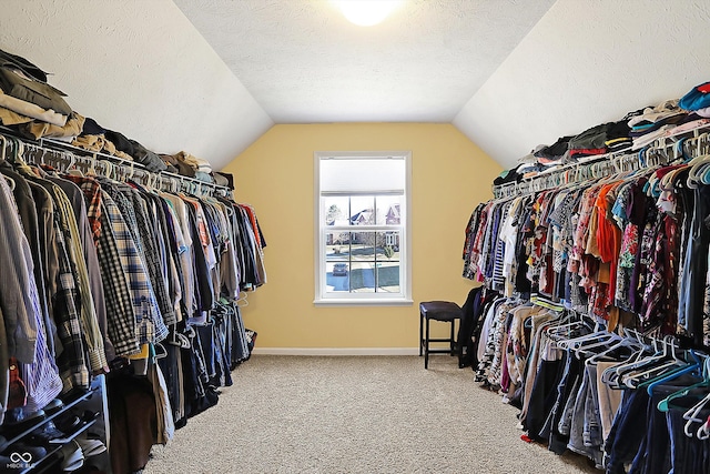 spacious closet featuring vaulted ceiling and carpet flooring