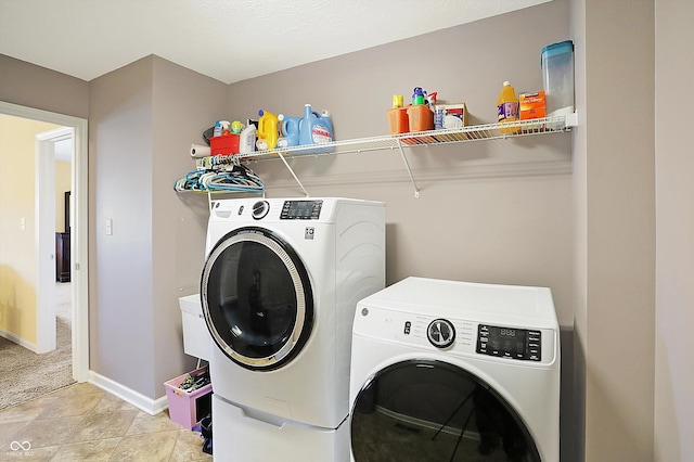 laundry room with laundry area, light tile patterned floors, baseboards, light colored carpet, and separate washer and dryer