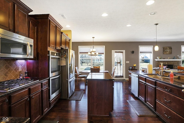 kitchen featuring tasteful backsplash, plenty of natural light, a kitchen island, and stainless steel appliances