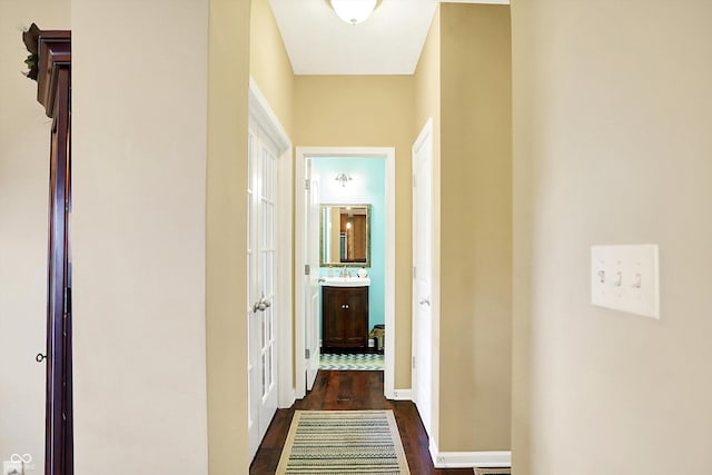 hall featuring dark wood-style floors and a sink