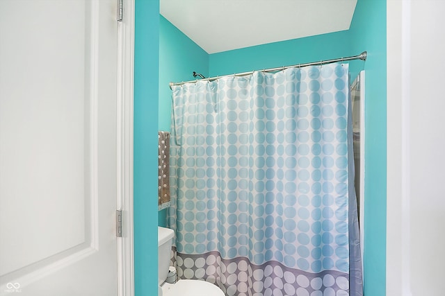 bathroom with a shower with curtain and toilet