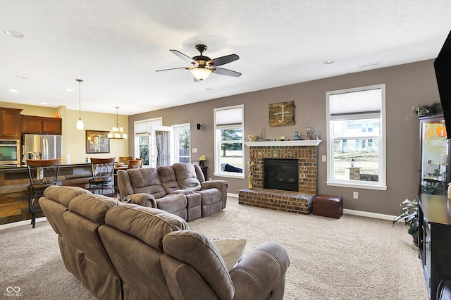 living area featuring a brick fireplace, ceiling fan, baseboards, and a textured ceiling