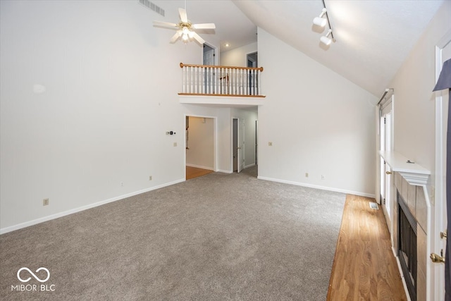 unfurnished living room featuring high vaulted ceiling, a ceiling fan, visible vents, baseboards, and a tiled fireplace