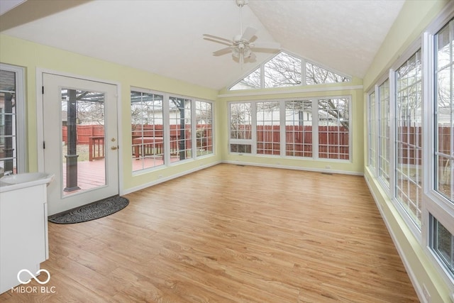 unfurnished sunroom featuring vaulted ceiling, ceiling fan, and plenty of natural light