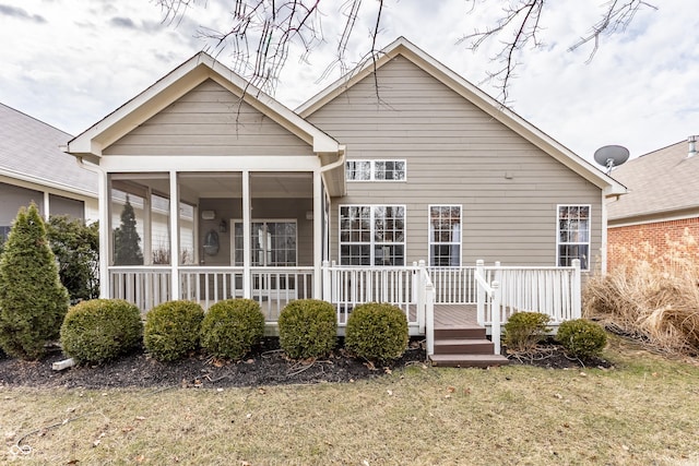 rear view of house featuring a yard and covered porch