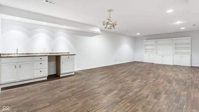 kitchen with a sink, visible vents, dark wood-type flooring, and open floor plan