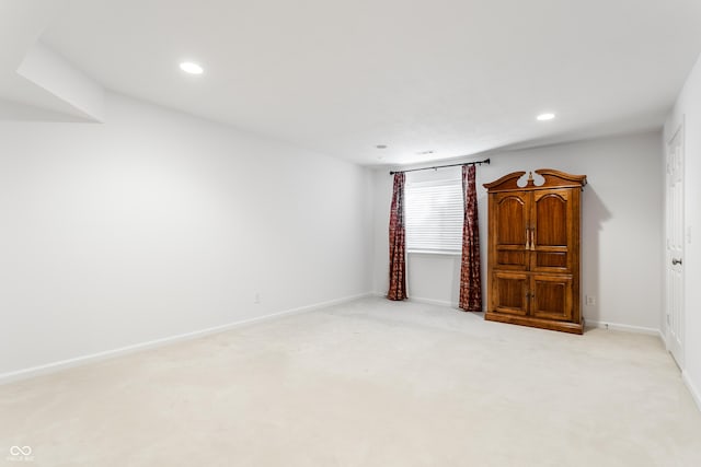 empty room with recessed lighting, light colored carpet, and baseboards