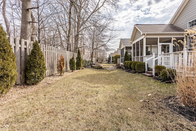 view of yard featuring a fenced backyard and a sunroom