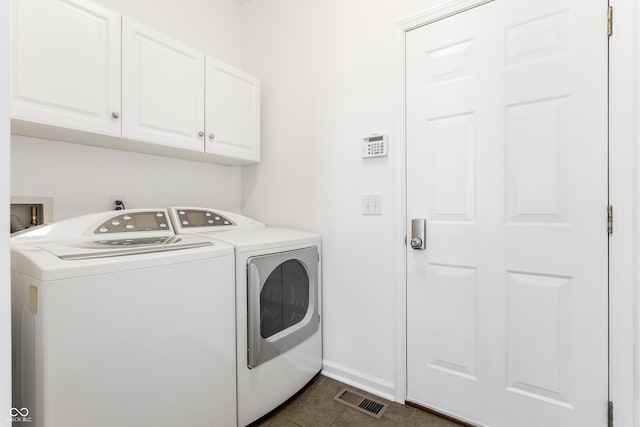 laundry room featuring visible vents, baseboards, washer and clothes dryer, cabinet space, and dark tile patterned flooring