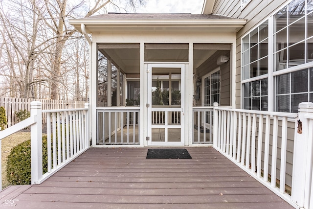 wooden deck featuring a sunroom and fence