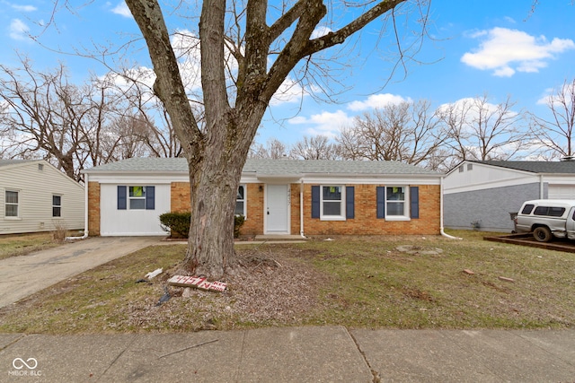 view of front of house with brick siding, roof with shingles, concrete driveway, and a front yard