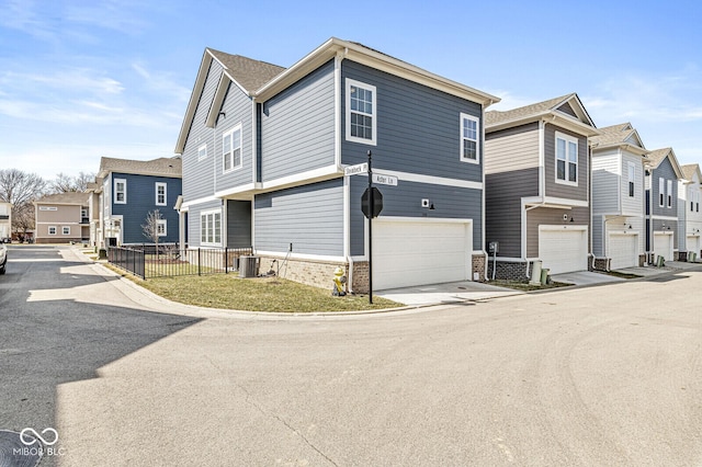 exterior space featuring brick siding, a residential view, a garage, and central AC