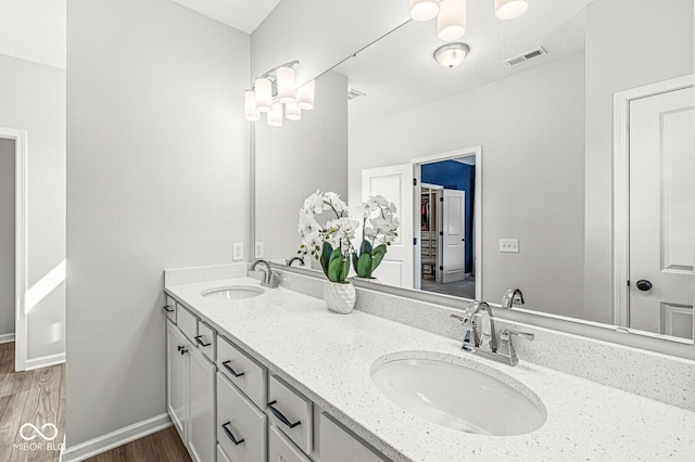 full bathroom with double vanity, visible vents, baseboards, and a sink