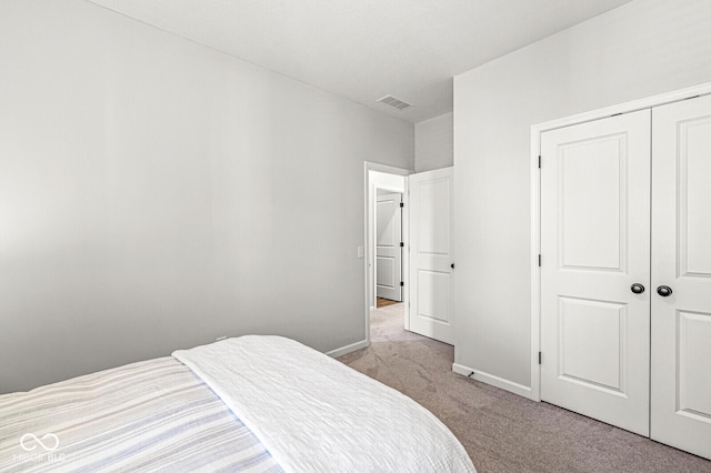 bedroom featuring a closet, visible vents, baseboards, and carpet floors