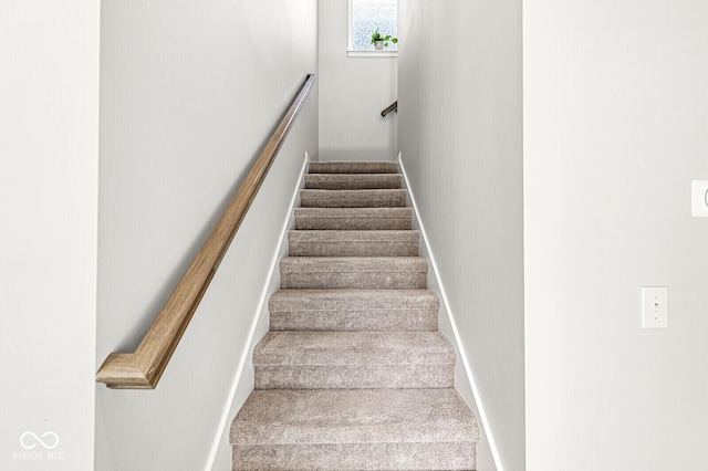 stairway featuring carpet flooring and baseboards