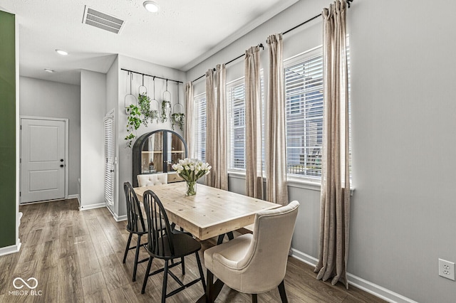 dining room with visible vents, baseboards, and wood finished floors