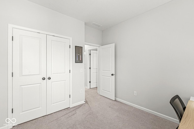 interior space featuring visible vents, baseboards, carpet, and a closet