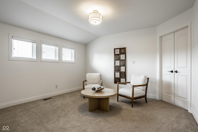 living area with baseboards, light carpet, vaulted ceiling, and visible vents