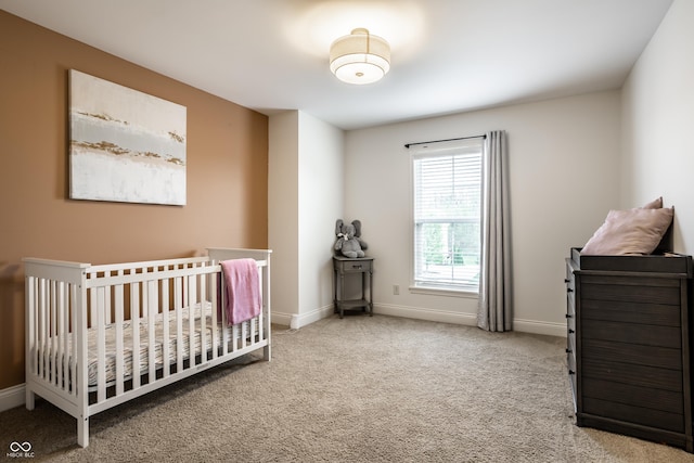carpeted bedroom with a nursery area and baseboards