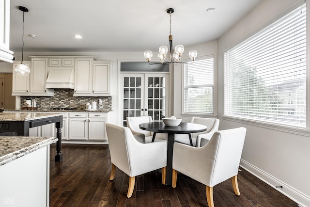 dining space with recessed lighting, baseboards, an inviting chandelier, and dark wood finished floors