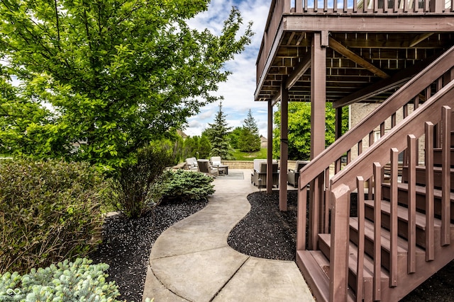 view of yard featuring a patio, a wooden deck, and stairs