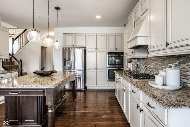 kitchen with dark wood-style flooring, appliances with stainless steel finishes, a breakfast bar, premium range hood, and backsplash