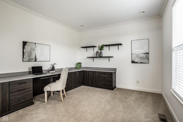 office space featuring crown molding, visible vents, light carpet, and built in study area