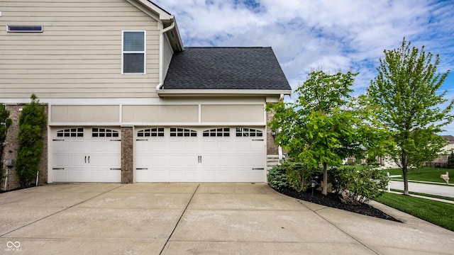 view of home's exterior with an attached garage, a shingled roof, and driveway