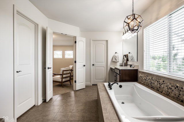 bathroom featuring a garden tub, an inviting chandelier, tile patterned floors, and vanity