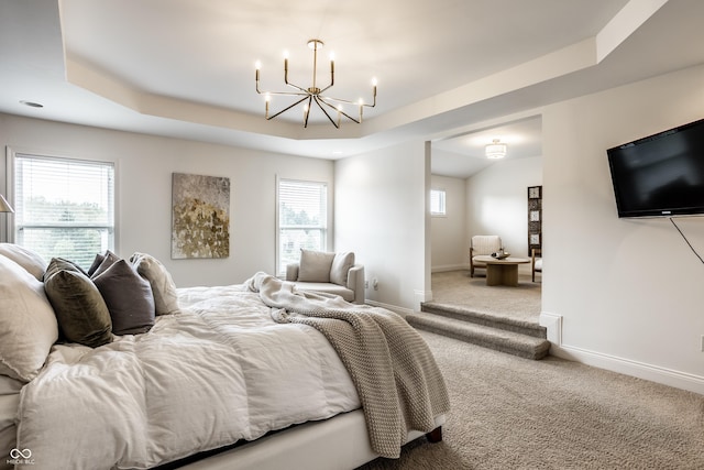 carpeted bedroom with baseboards, a raised ceiling, and a notable chandelier
