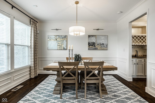 dining area with visible vents, plenty of natural light, dark wood-type flooring, and a decorative wall
