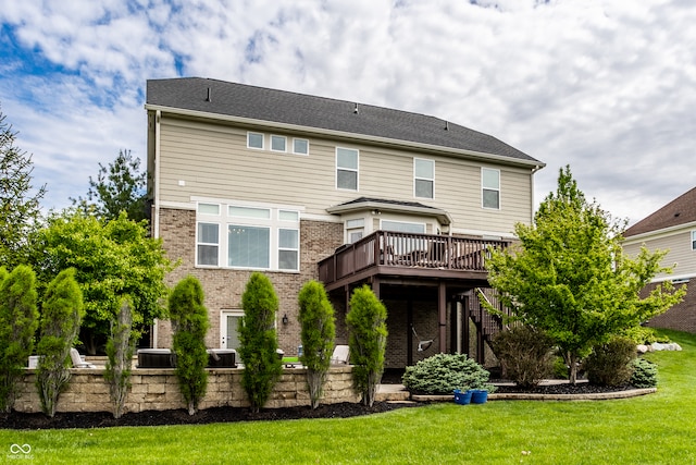 back of property with a yard, a deck, brick siding, and stairs