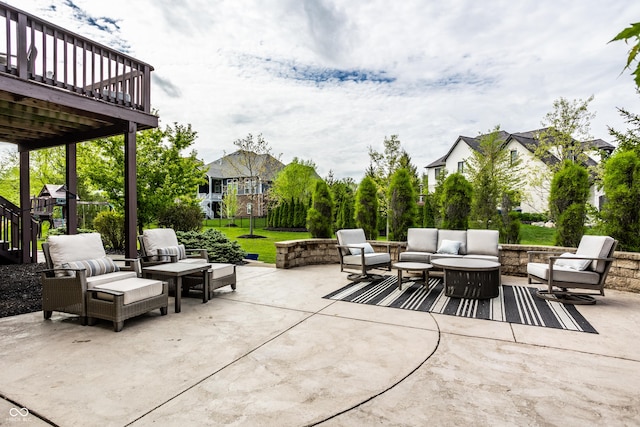 view of patio / terrace featuring a deck and an outdoor living space with a fire pit