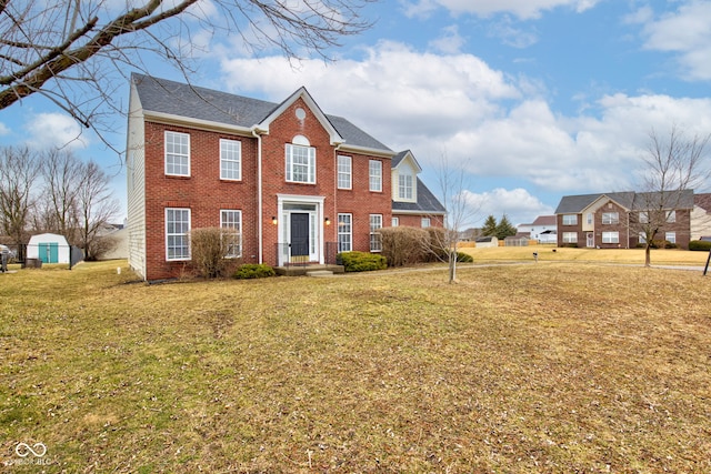 colonial inspired home featuring a front yard and brick siding