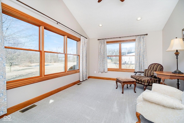 sitting room with lofted ceiling, plenty of natural light, visible vents, and carpet flooring