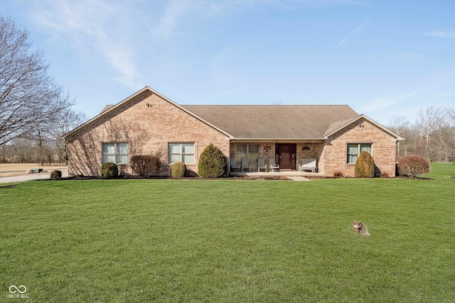 ranch-style house featuring brick siding, roof with shingles, and a front lawn
