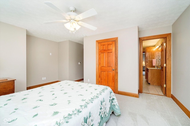 bedroom featuring a ceiling fan, baseboards, a textured ceiling, and light colored carpet