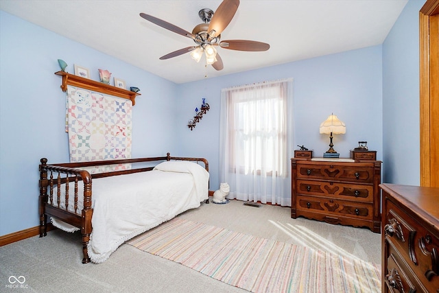 carpeted bedroom featuring a ceiling fan, visible vents, and baseboards