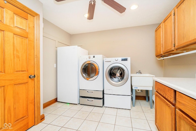 laundry room with light tile patterned flooring, a sink, a ceiling fan, cabinet space, and washer and clothes dryer