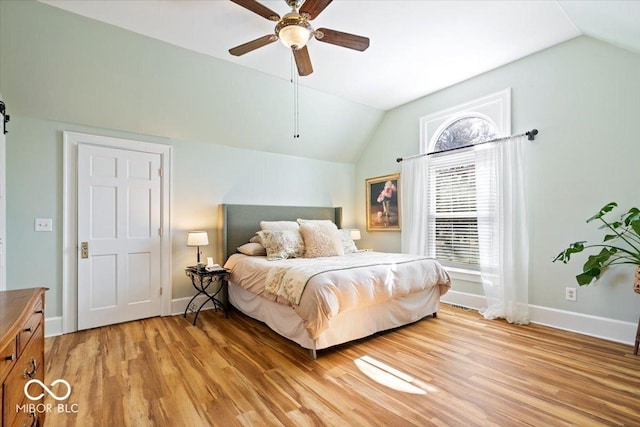 bedroom featuring a ceiling fan, vaulted ceiling, light wood-style floors, and baseboards