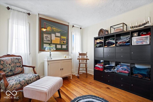 sitting room with light wood-style flooring and a textured ceiling