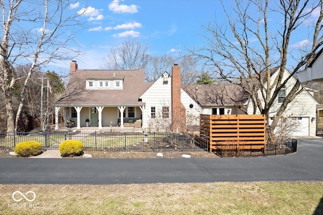 view of front of home featuring a fenced front yard, a garage, a porch, and a chimney