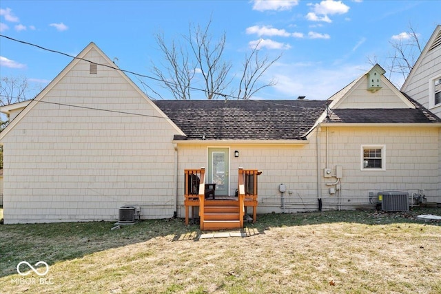 view of front of property featuring a front yard, central AC, and roof with shingles