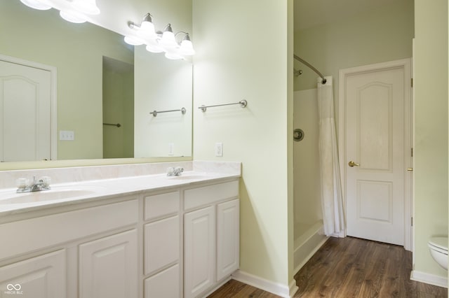 full bathroom with curtained shower, wood finished floors, a sink, and double vanity