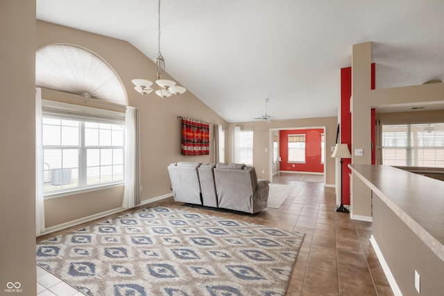 living area with lofted ceiling, baseboards, and tile patterned floors