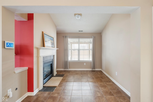 unfurnished living room with baseboards, a tile fireplace, visible vents, and tile patterned floors