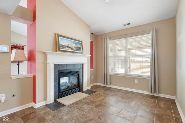 unfurnished living room featuring lofted ceiling, baseboards, visible vents, and a tiled fireplace