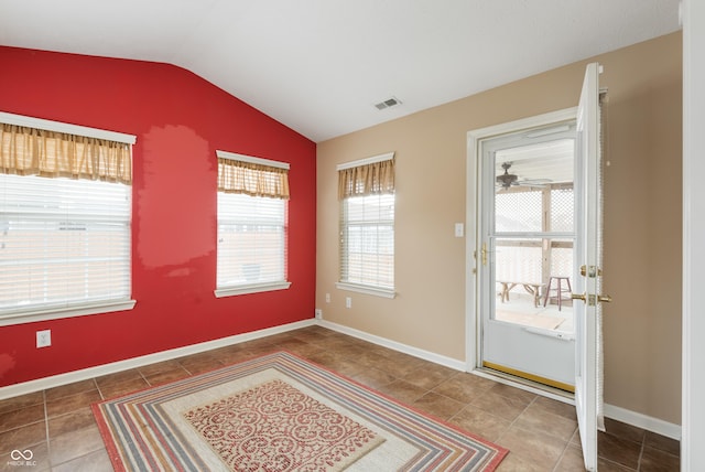 doorway featuring lofted ceiling, tile patterned floors, visible vents, and baseboards