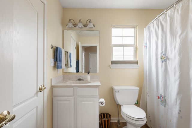 bathroom featuring vanity, toilet, and baseboards