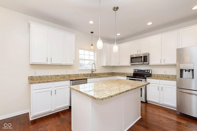 kitchen featuring stainless steel appliances, a sink, white cabinetry, a center island, and dark wood-style floors